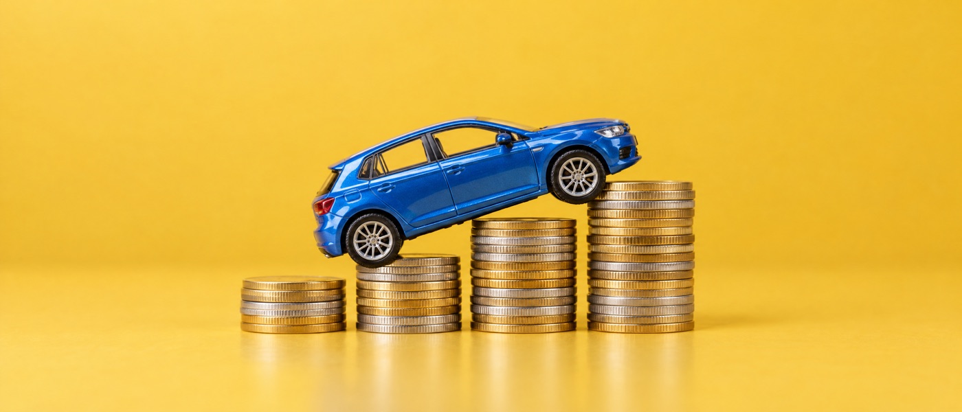 Blue toy car climbing stacks of gold and silver coins